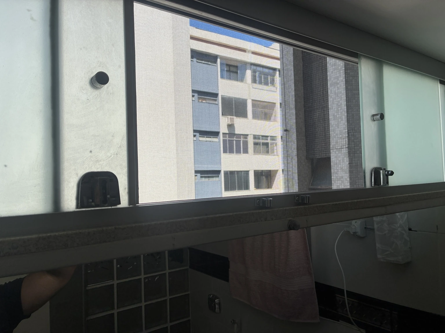 Tela mosquiteira na janela menor do apartamento, vista pelo interior na SQN 111, Bloco I, Asa Norte, Brasília DF