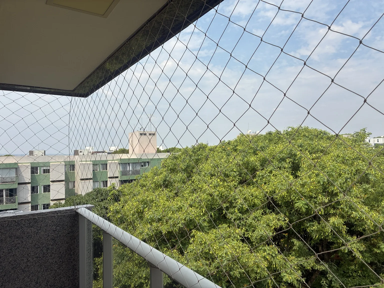 Rede instalada no vão da varanda, acima do guarda-corpo.