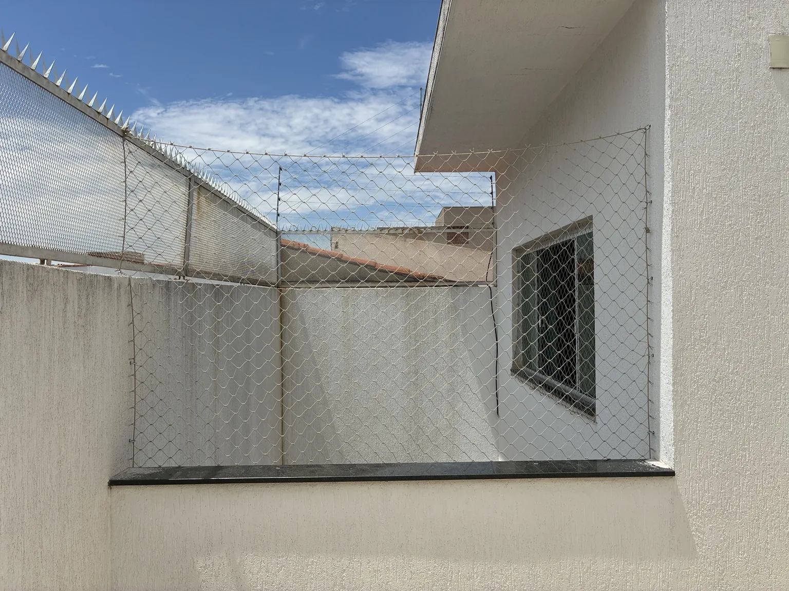 Rede de proteção no vão externo acima da mureta.