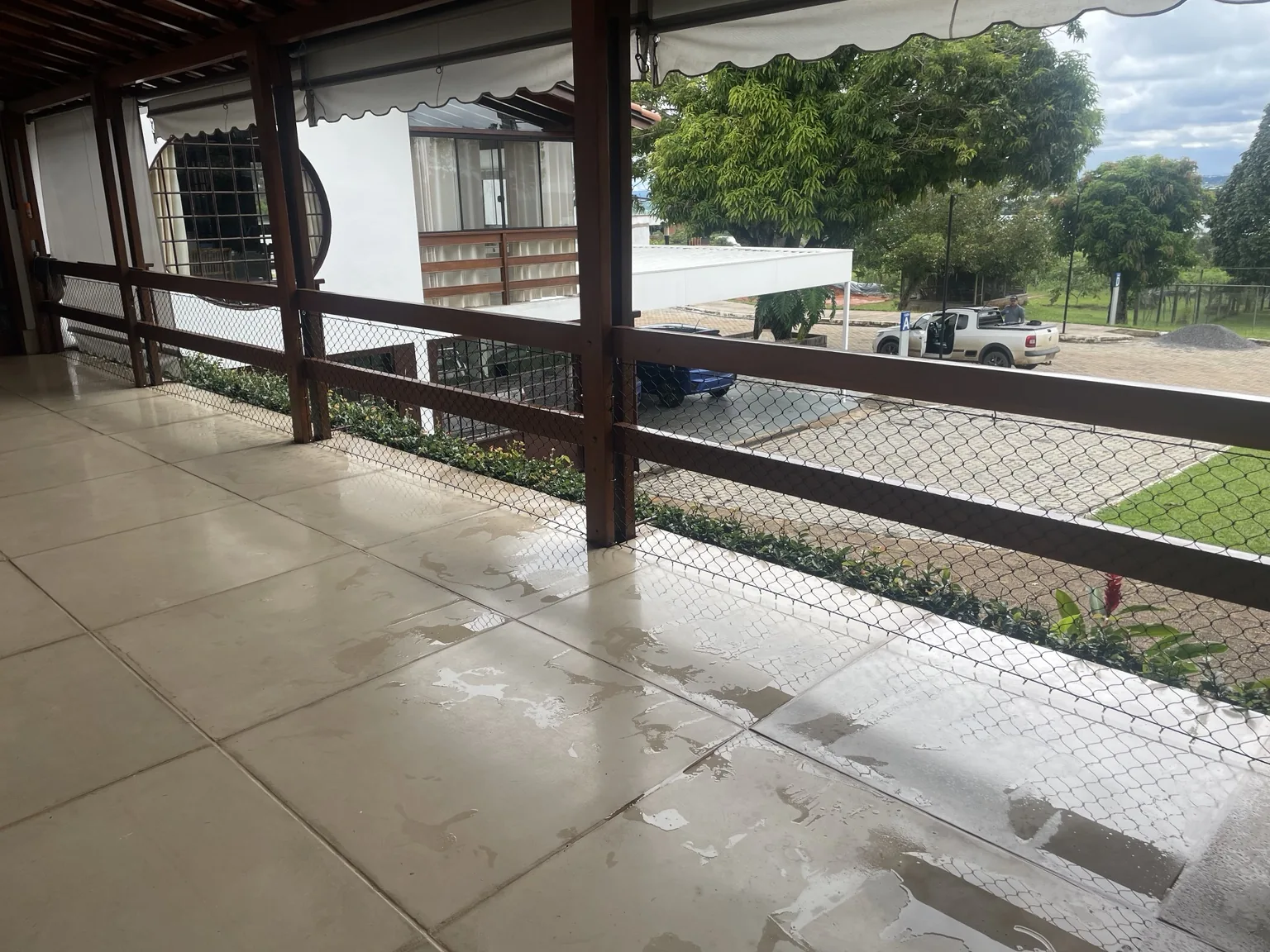 Rede preta instalada junto ao guarda-corpo de madeira da residência