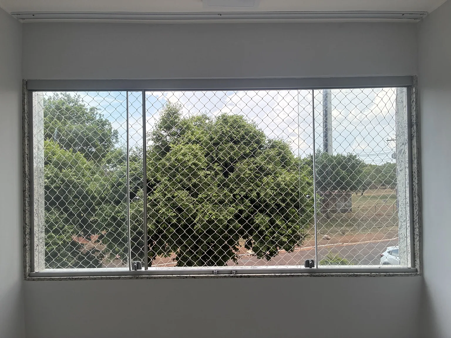 Vista frontal do conjunto de janelas com rede de proteção areia.