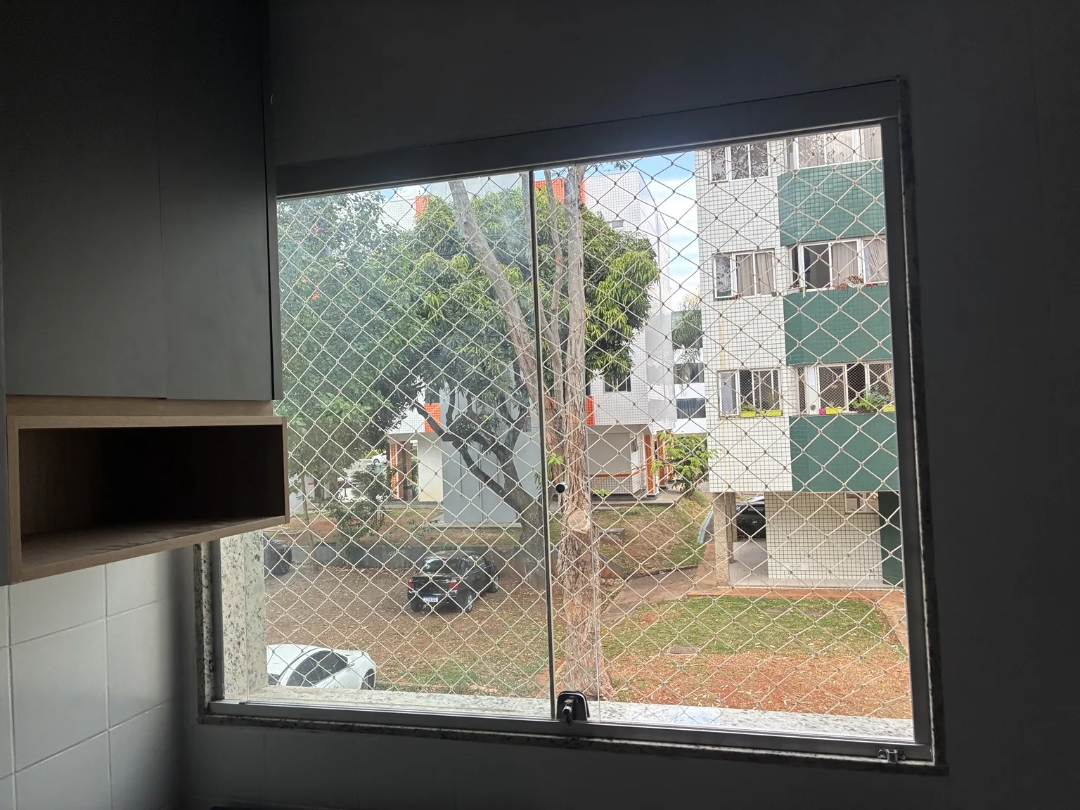 Rede de proteção junto à janela, vista pelo interior do apartamento.