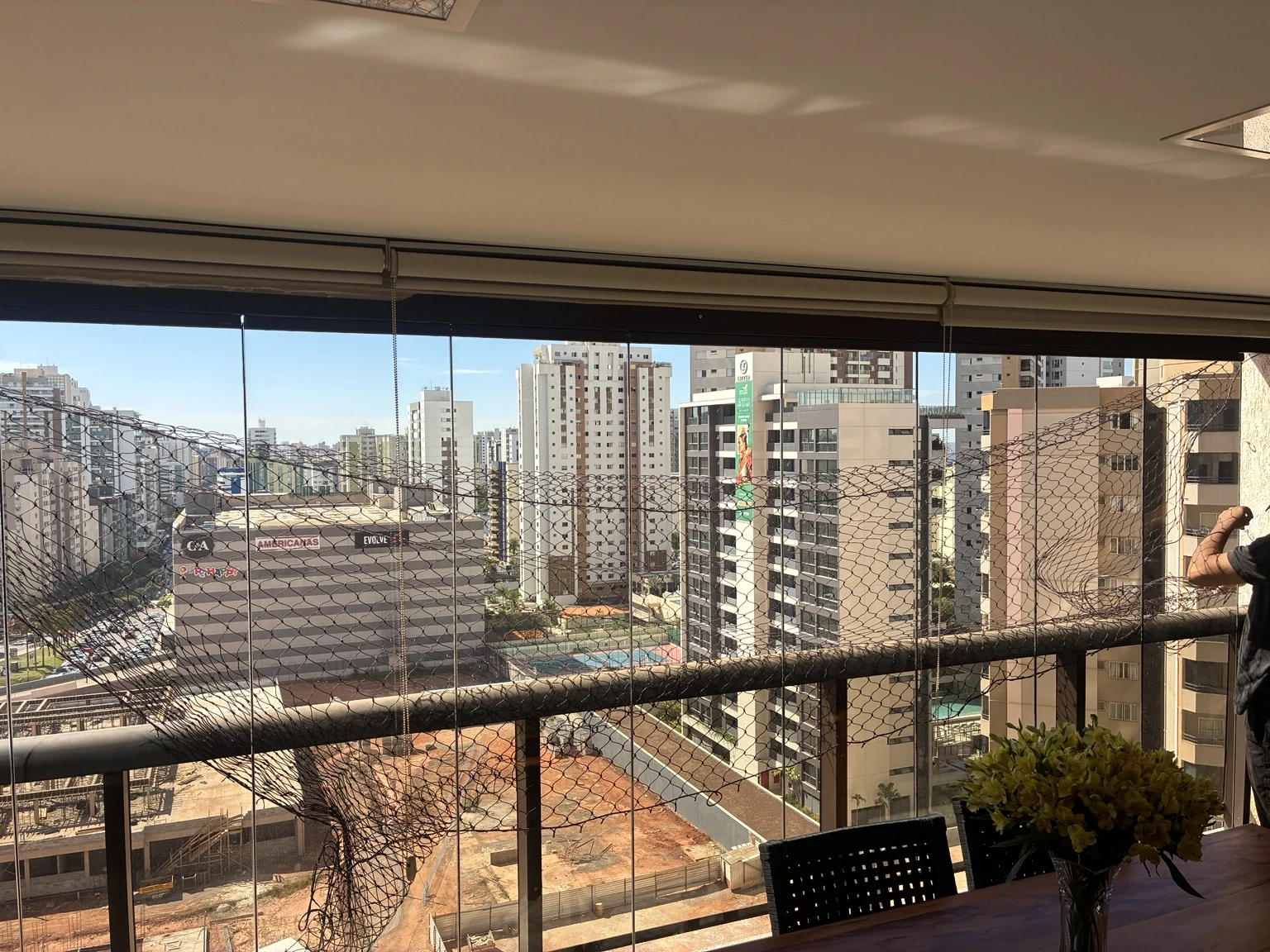 Etapa da instalação na varanda: rede ainda solta durante o trabalho, antes da fixação final.
