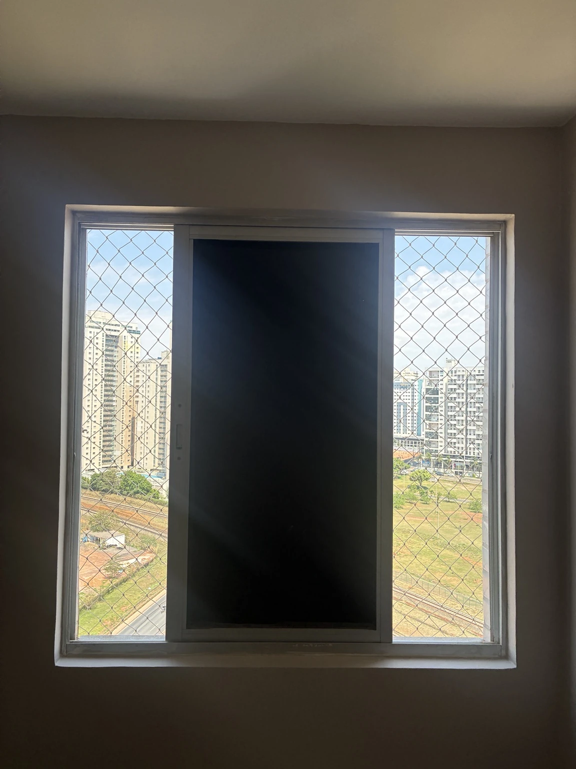 Janela de correr com rede de proteção visível nas laterais no Ed. Spetaculo Clube Residencial, Avenida Sibipiruna, Águas Claras