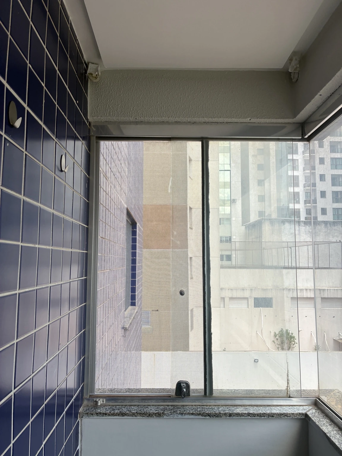 Tela no fechamento lateral próximo à parede de revestimento azul no Edifício Osório de Moraes, Rua 8 Norte, Lote 1, Águas Claras