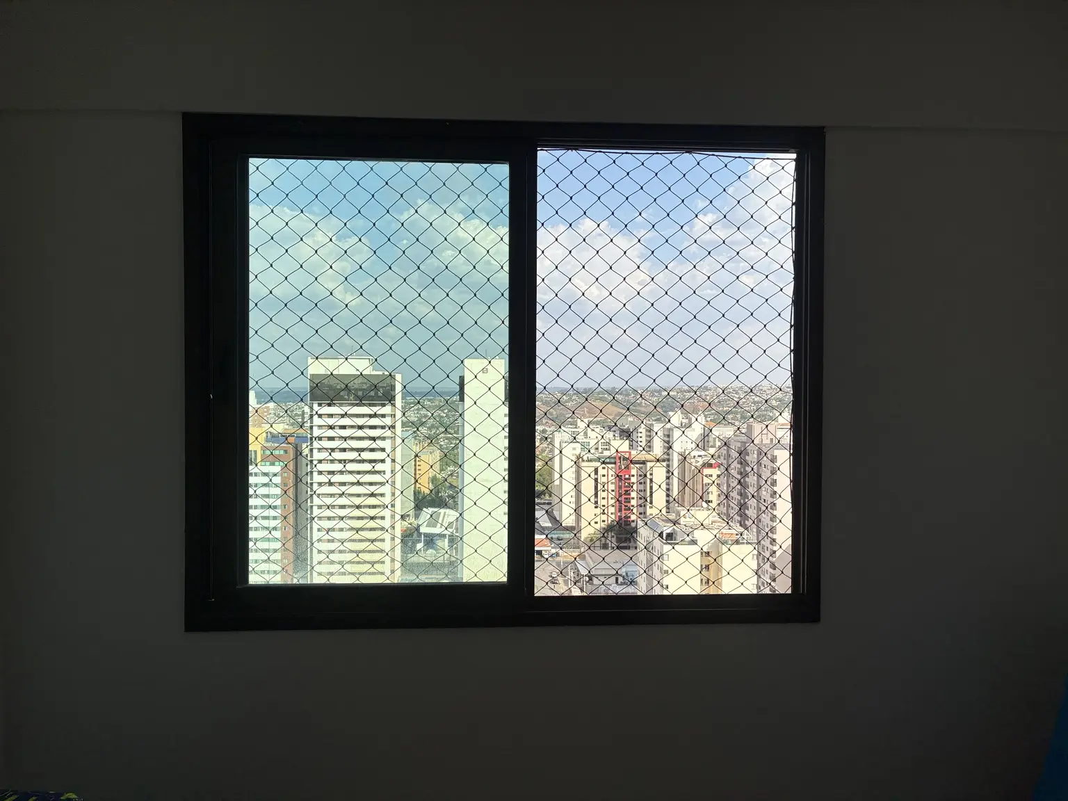Rede de proteção preta 5×5 cm instalada em janela do Edifício Mirante das Águas, Águas Claras