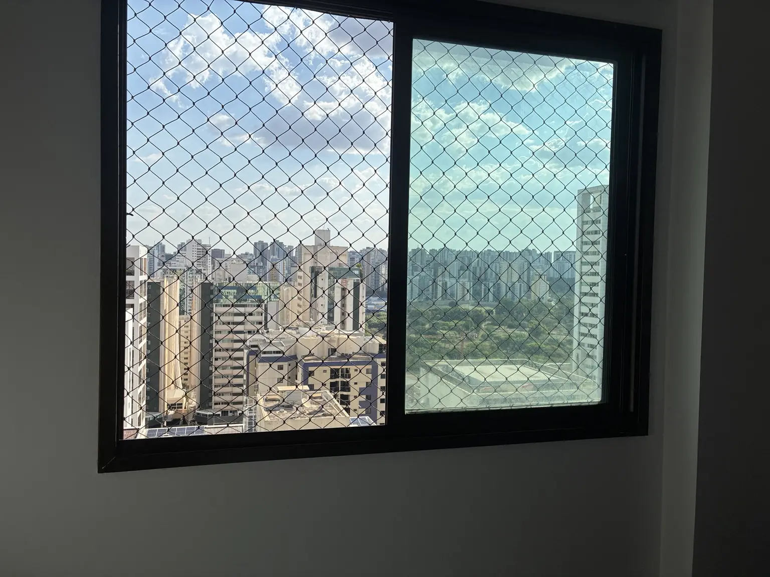 Janela protegida por rede preta 5×5 cm em apartamento de Águas Claras
