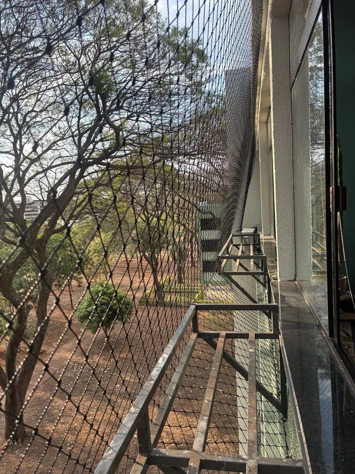 Detalhe da malha preta junto à esquadria e aos suportes externos — SQN 411, Bloco K, Asa Norte.