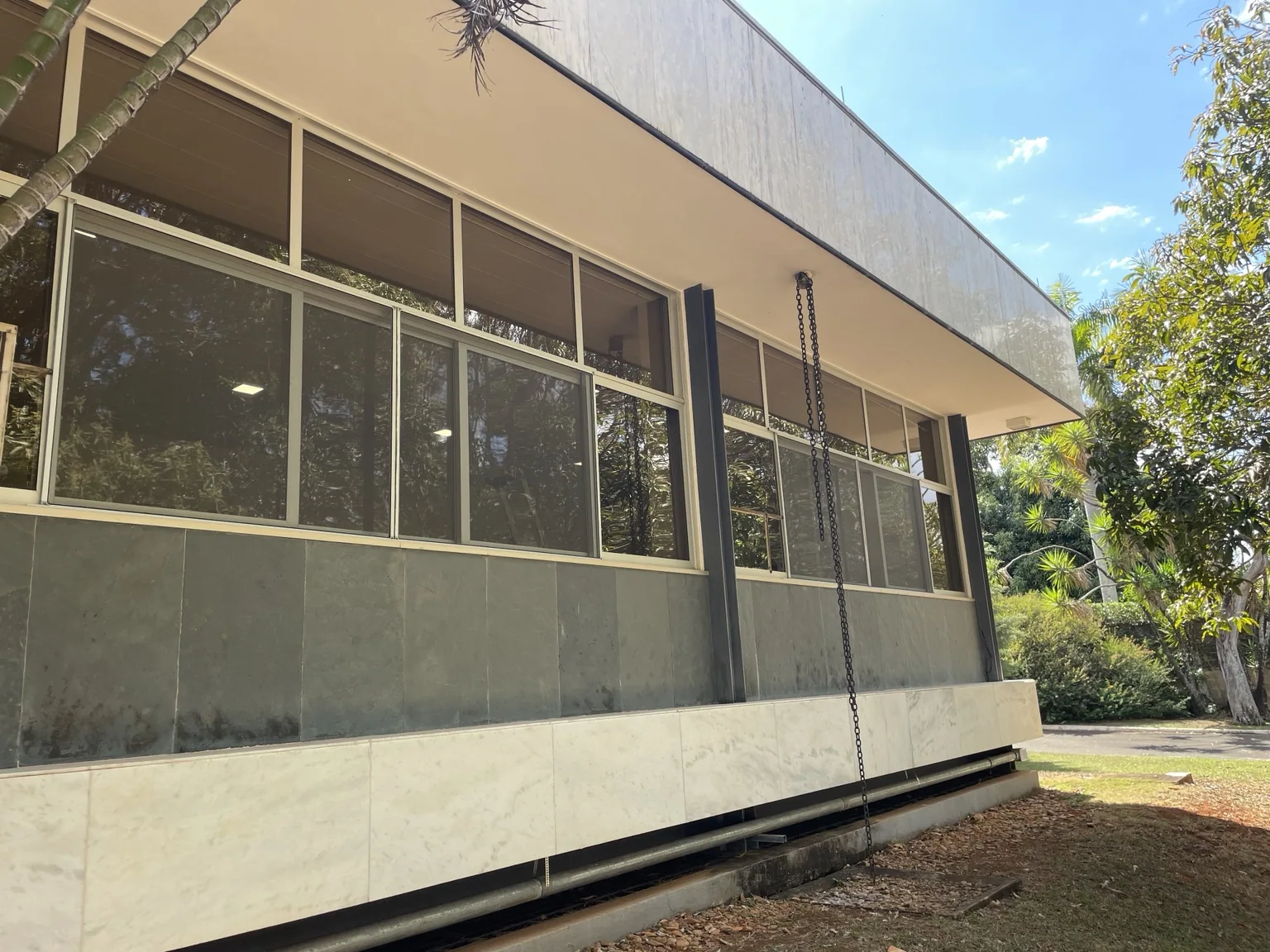 Janelas da fachada com tela mosquiteira e esquadria clara na SES 809