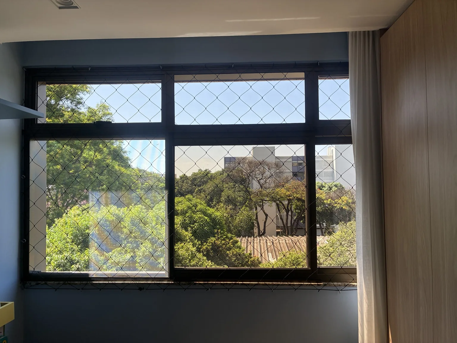 Janela com tela mosquiteira bronze e rede preta na SQS 102, Bloco A.