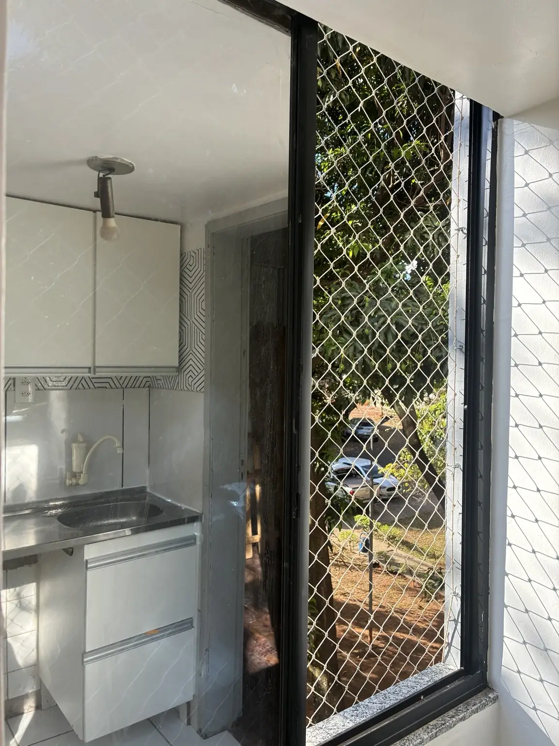 Rede de proteção na janela da cozinha, com fixação junto ao contorno do vão.