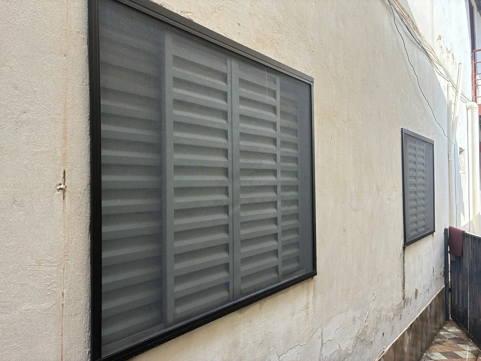 Vista externa do conjunto de janelas com tela mosquiteira preta — Chácara 23A, Colônia Agrícola Águas Claras.