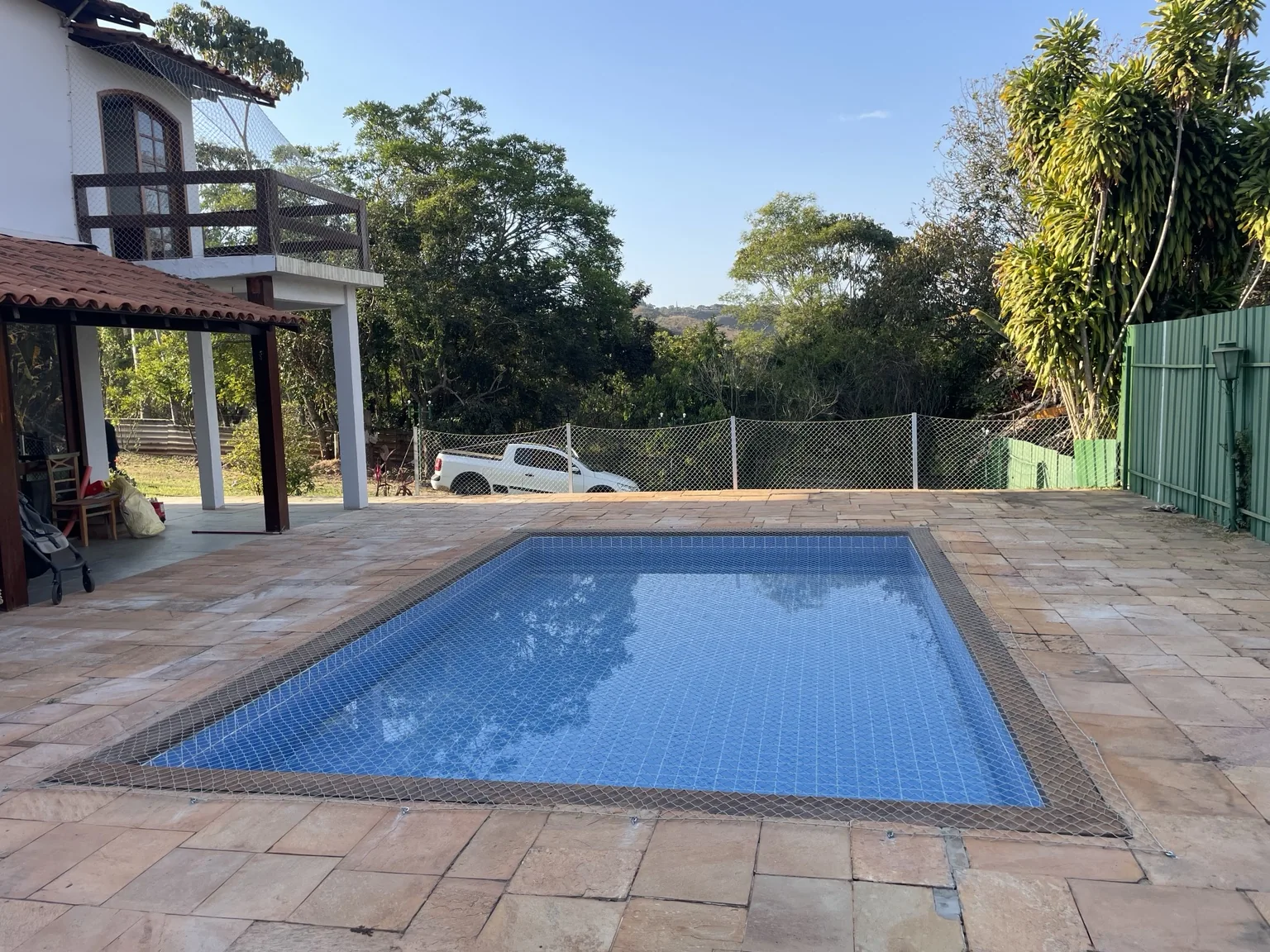Área da piscina da residência no Solar da Serra com rede de proteção