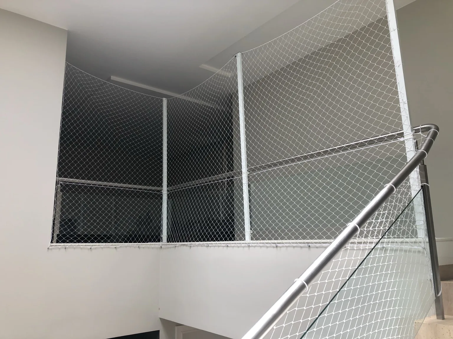 Rede branca 5×5 cm instalada em vão interno junto à escada no Lago Sul