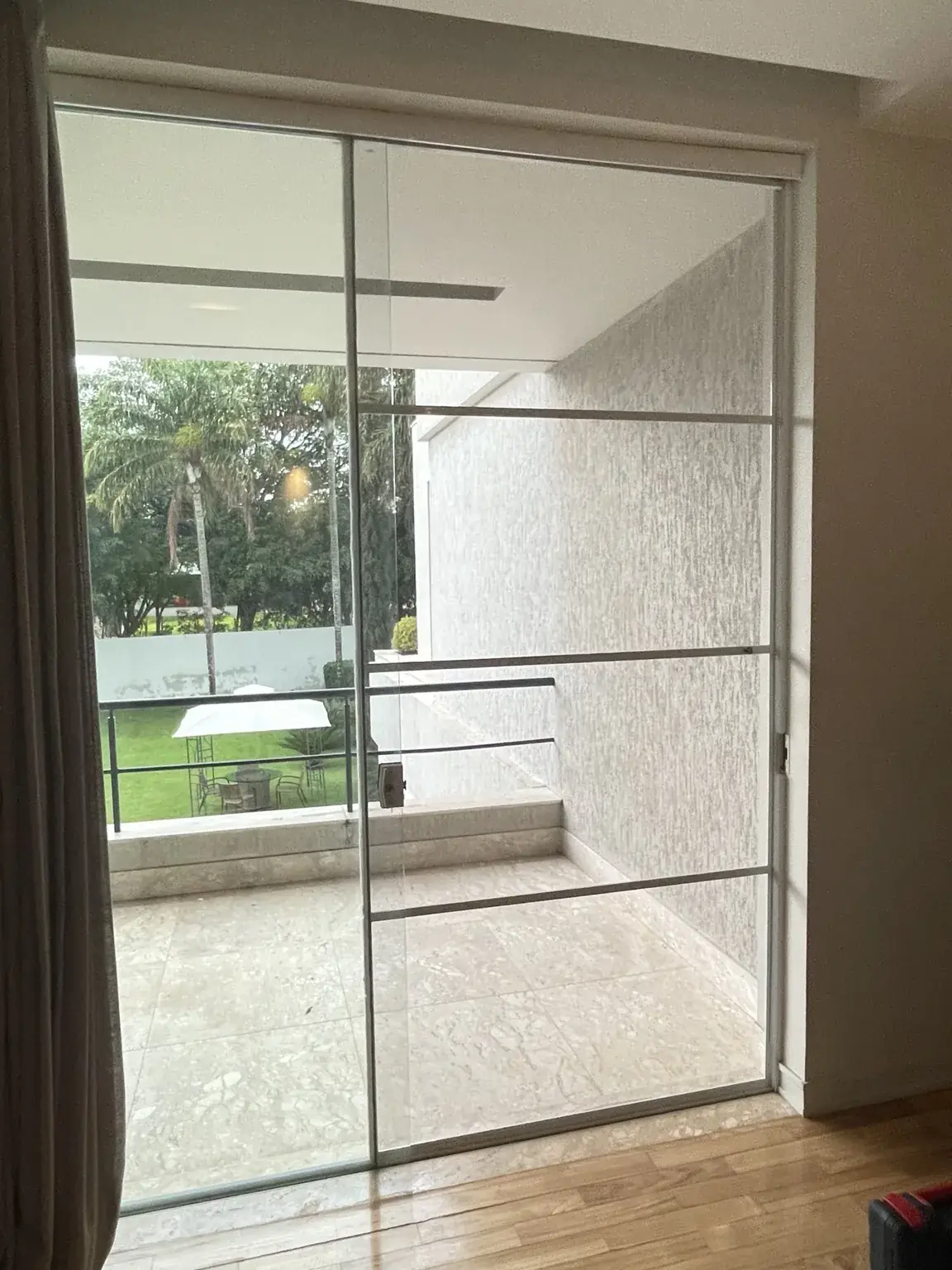 Abertura de correr com acabamento branco vista pelo interior da residência oficial