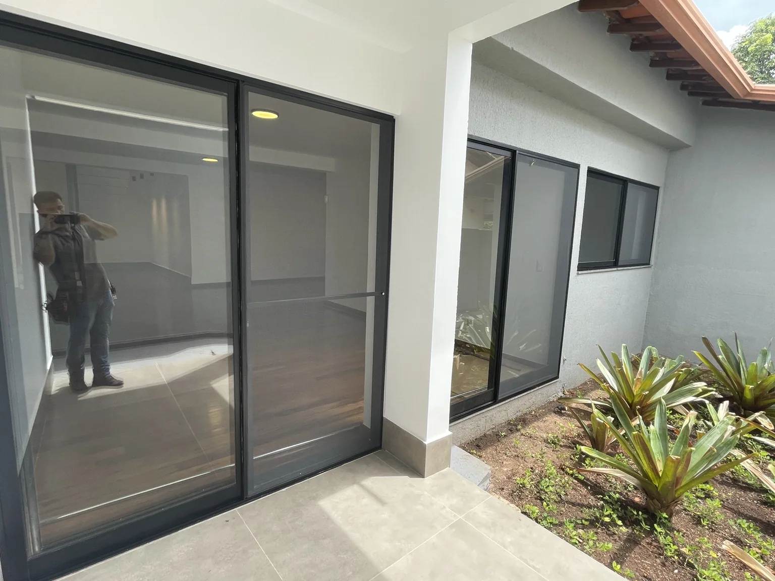 Porta com tela mosquiteira preta voltada para o jardim