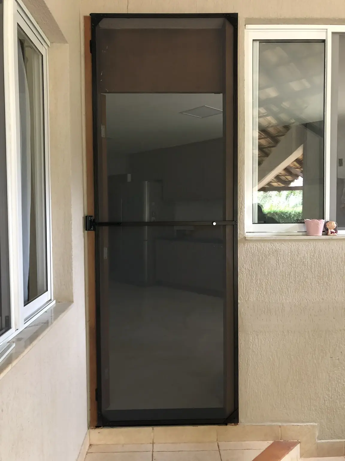 Porta auxiliar com tela mosquiteira de acabamento escuro na SMPW Quadra 17, Conjunto 4, Lote 1, Park Way
