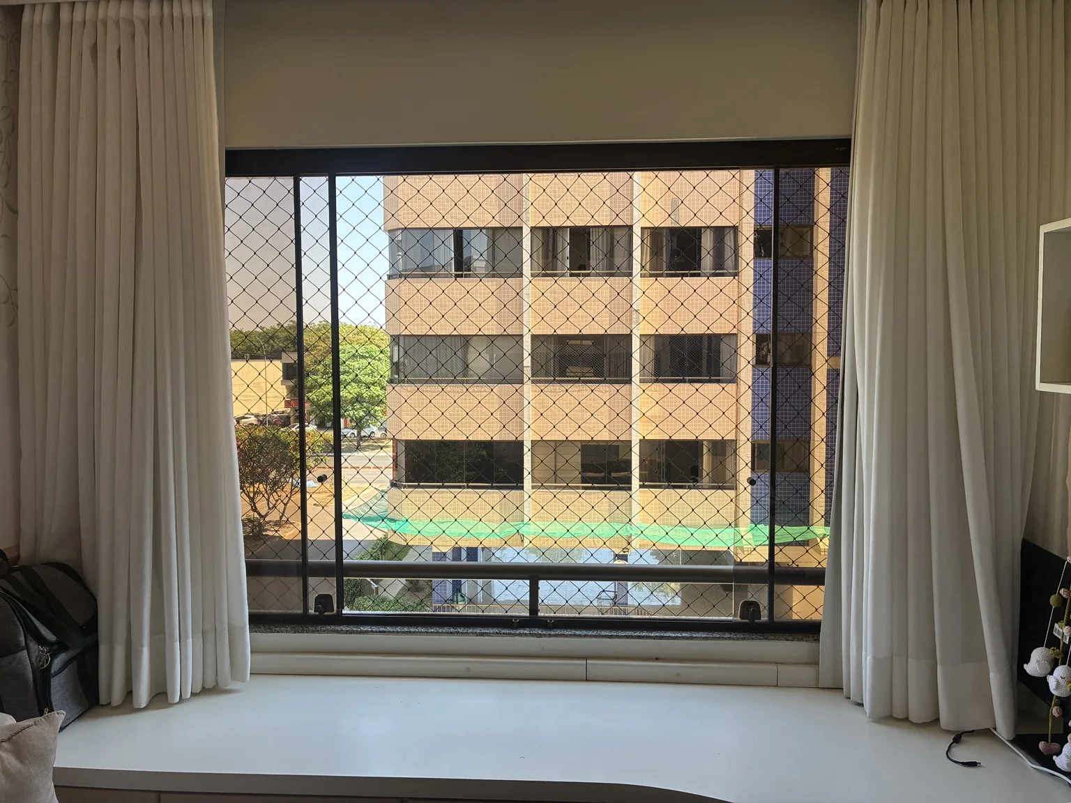 Rede de proteção preta 5×5 cm em janela do Edifício Porto Parati no Sudoeste