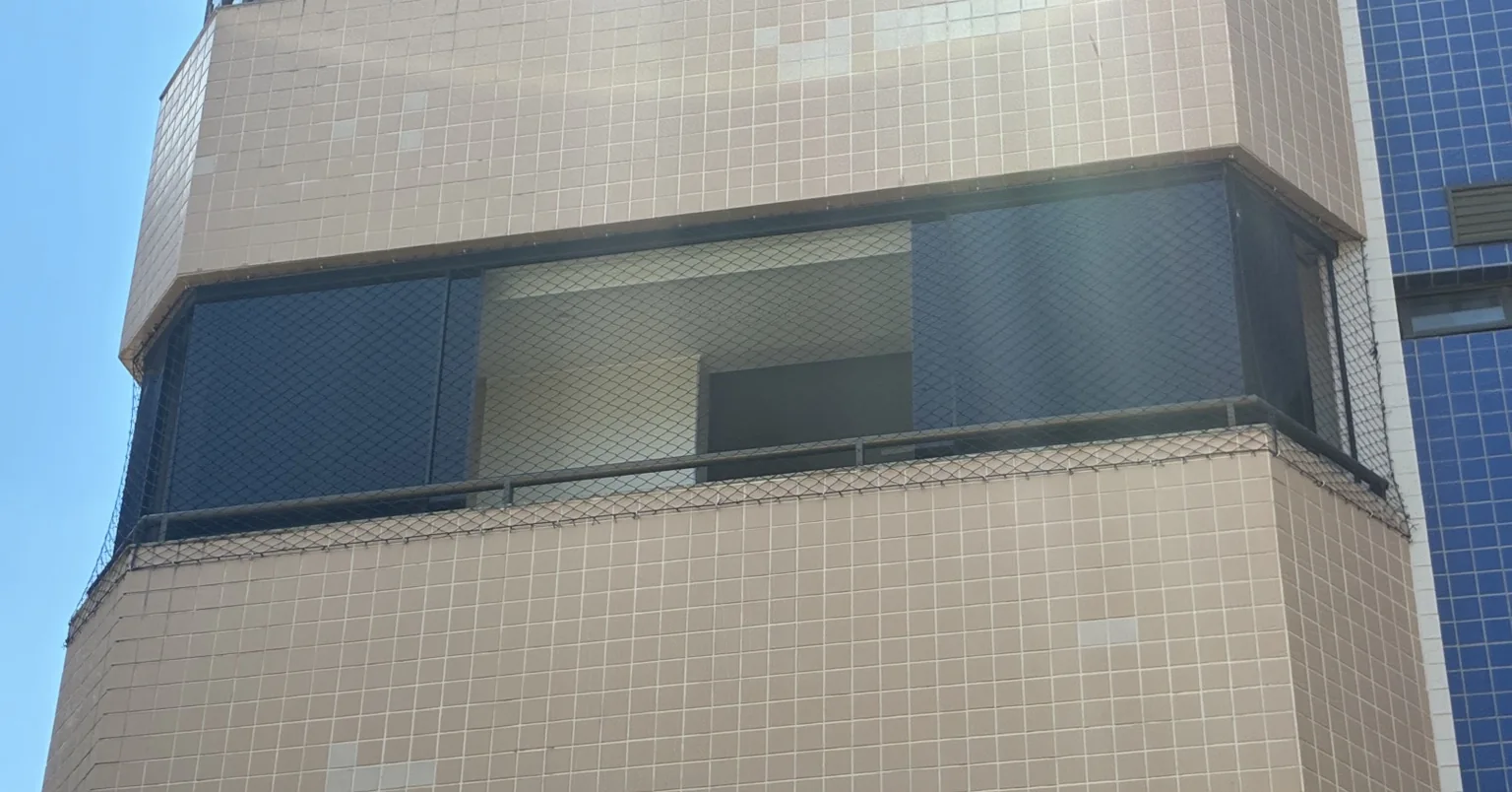 Rede preta vista do exterior em janela do Bloco B do Porto Parati