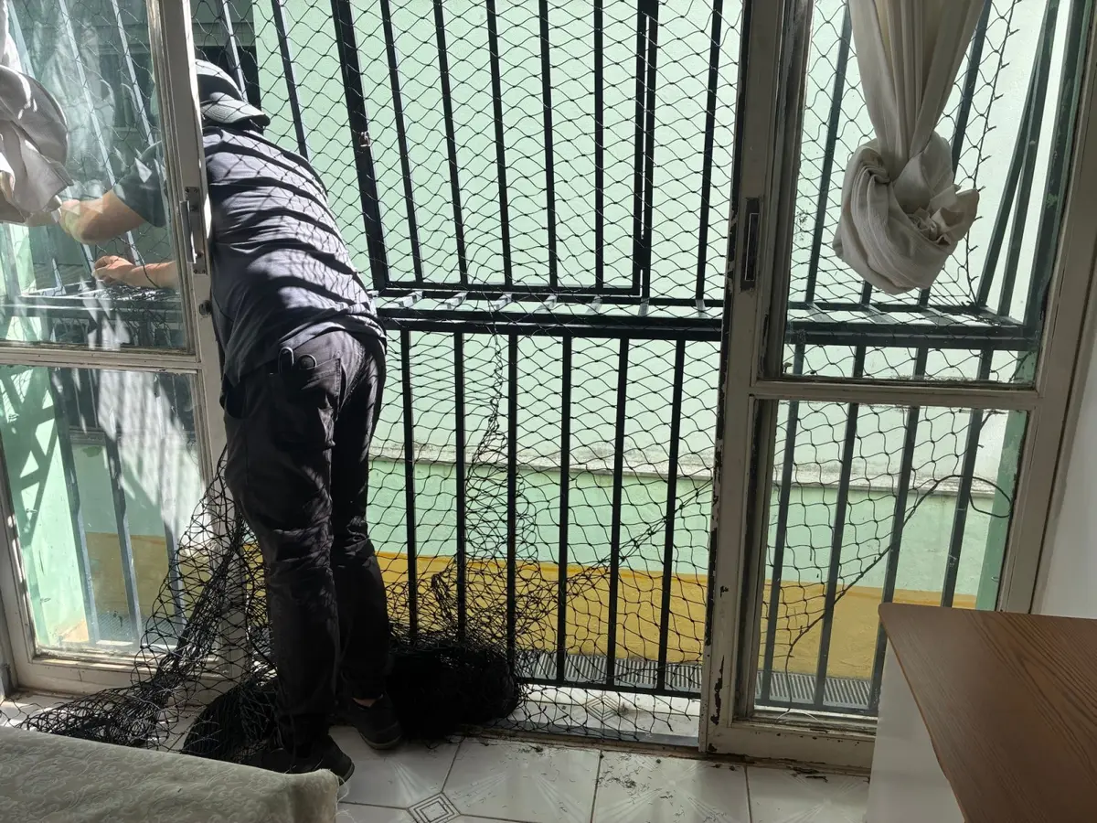 Profissional instalando rede de proteção em varanda